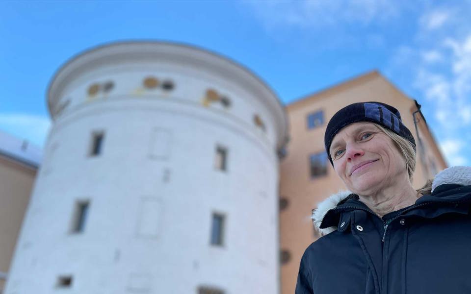 Byggnadsarkeolog framför ett runt vitt torn.