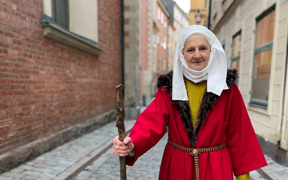 Medeltida klädd kvinna i en gränd i Gamla stan.